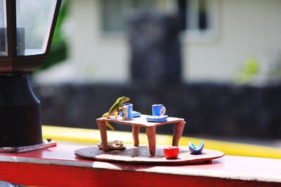 Craftwork of lizard and cups on table at retaining wall