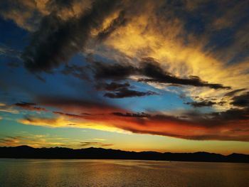 Scenic view of sea against cloudy sky at sunset