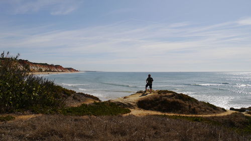 Man on beach by sea against sky