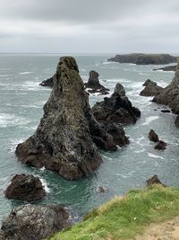 Rock formation on sea shore against sky