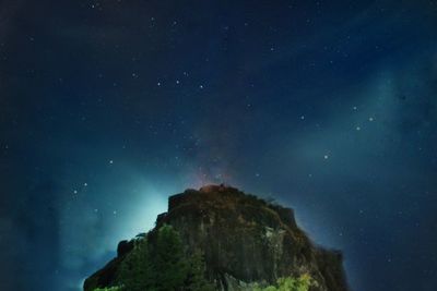 Low angle view of rock formation against sky at night