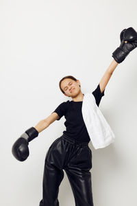 Portrait of young woman exercising against white background