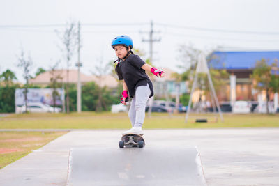 Side view of boy skateboarding on road