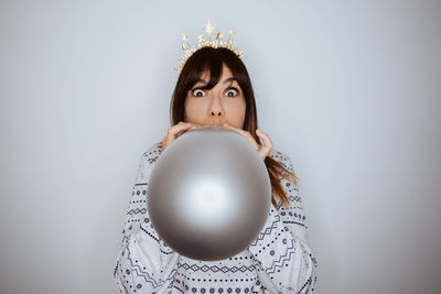 Portrait of young woman standing against white background