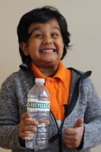 Close-up portrait of boy against gray background