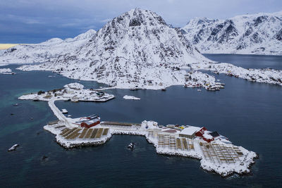 High angle view of snowcapped mountains by sea against sky