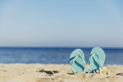 Flip flops stuck in the sand on a sandy beach by the sea or ocean