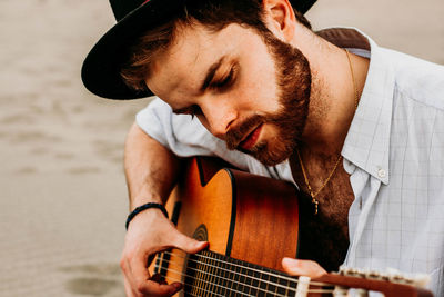 Young man playing guitar at beach