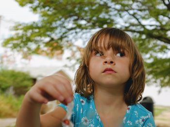 Girl looking away while standing at park