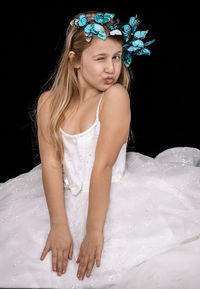 Close-up of girl looking away against black background