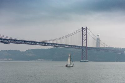 Suspension bridge over sea against sky