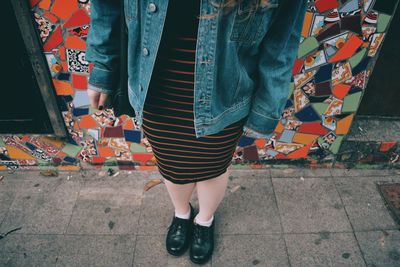 Low section of woman standing on road