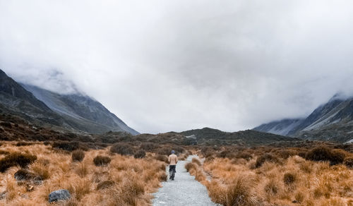 Rear view of people walking on mountain road