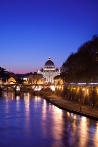 Illuminated buildings against sky at dusk