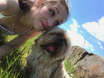 Portrait of woman with dog against sky