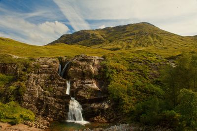 Scenic view of waterfall against sky
