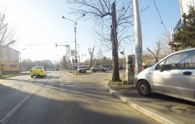 Cars on road against sky in city