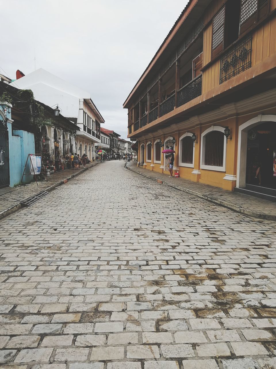 COBBLESTONE STREET AMIDST BUILDINGS IN CITY