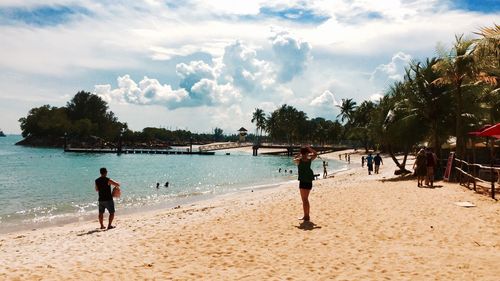 People on beach against sky