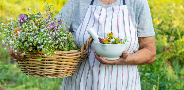 Midsection of woman holding potted plant