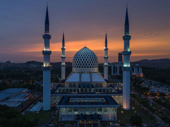 Communications tower in city at sunset