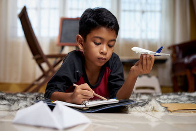 Full length of a boy sitting on table