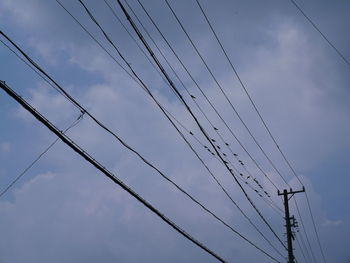 Low angle view of power cables against sky
