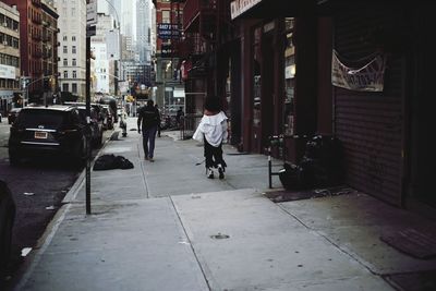 Man walking on street amidst buildings in city