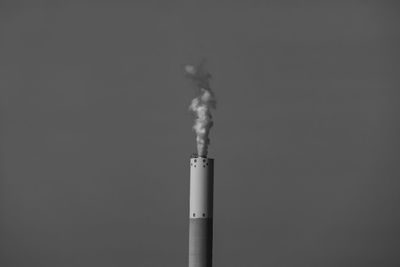 Low angle view of smoke emitting from chimney against sky