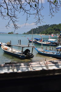 Boats moored on sea against sky