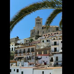 Buildings in city against blue sky