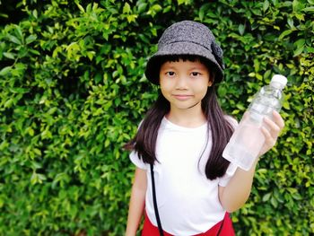 Portrait of smiling girl standing against plants
