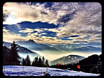 Snow covered landscape against cloudy sky