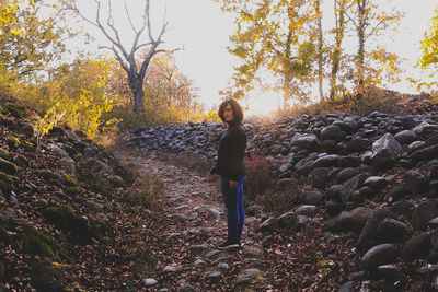 Young woman standing on rock in forest