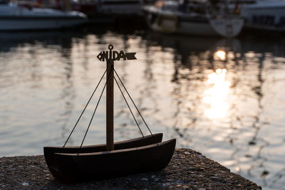 Wooden boat souvenir with red and light lighthouse, boat and tourists on background, nida, lithuania