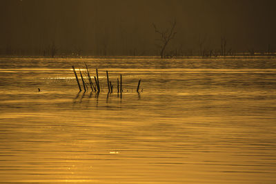 Scenic view of lake against sky at sunset