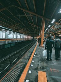 Rear view of people on railroad station platform