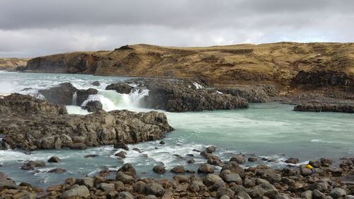Scenic view of rocks in sea against sky