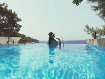 Rear view of man swimming in pool