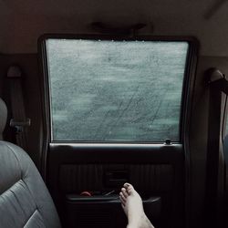 Low section of person in car during rainy season