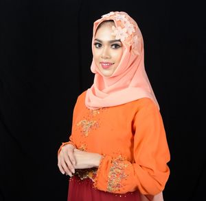 Midsection of woman wearing mask against black background