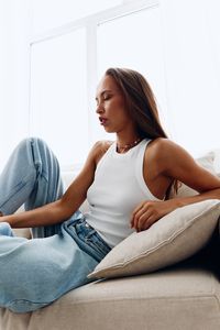 Young woman sitting on sofa at home