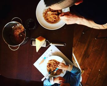 High angle view of woman holding coffee cup on table