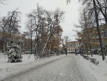 Snow covered street amidst buildings in city