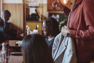 Happy woman with male and female friends in bar afterwork