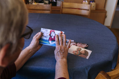 Senior woman with photographs of family at home