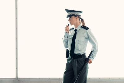 Man looking away while standing against wall