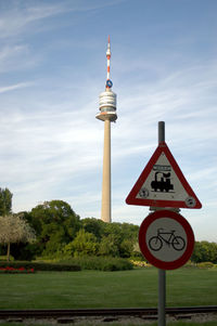 Information sign by road against sky