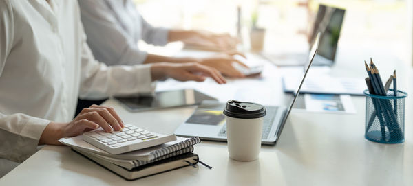 Midsection of business colleagues working on table