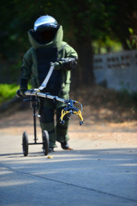 Full length of man wearing protective suit walking on road